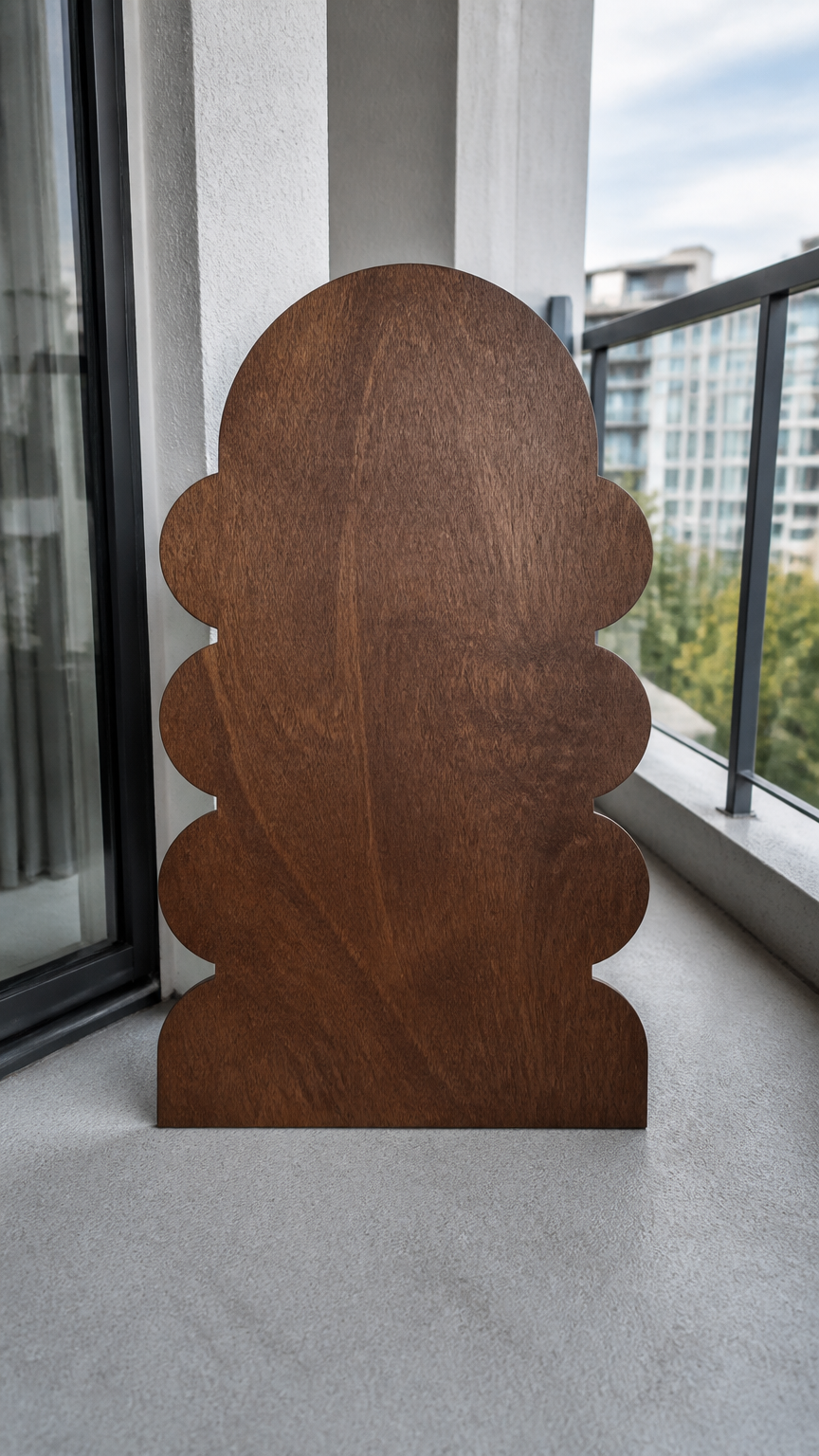 A custom-cut outdoor-grade plywood sheet stained in a rich walnut finish, resting on a clean apartment balcony, shot...
